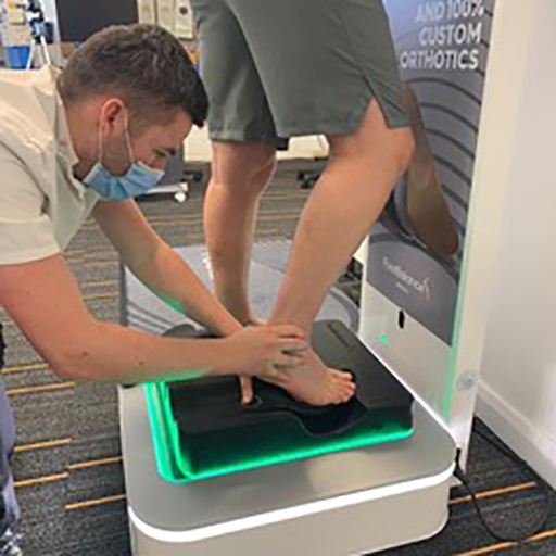 Sports podiatrist alining a foot on a sports podiatrsit machine